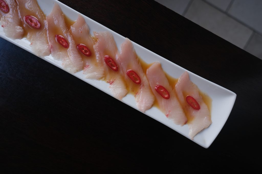 Yellowtail carpaccio with citrus sauce for a business lunch in Soho
